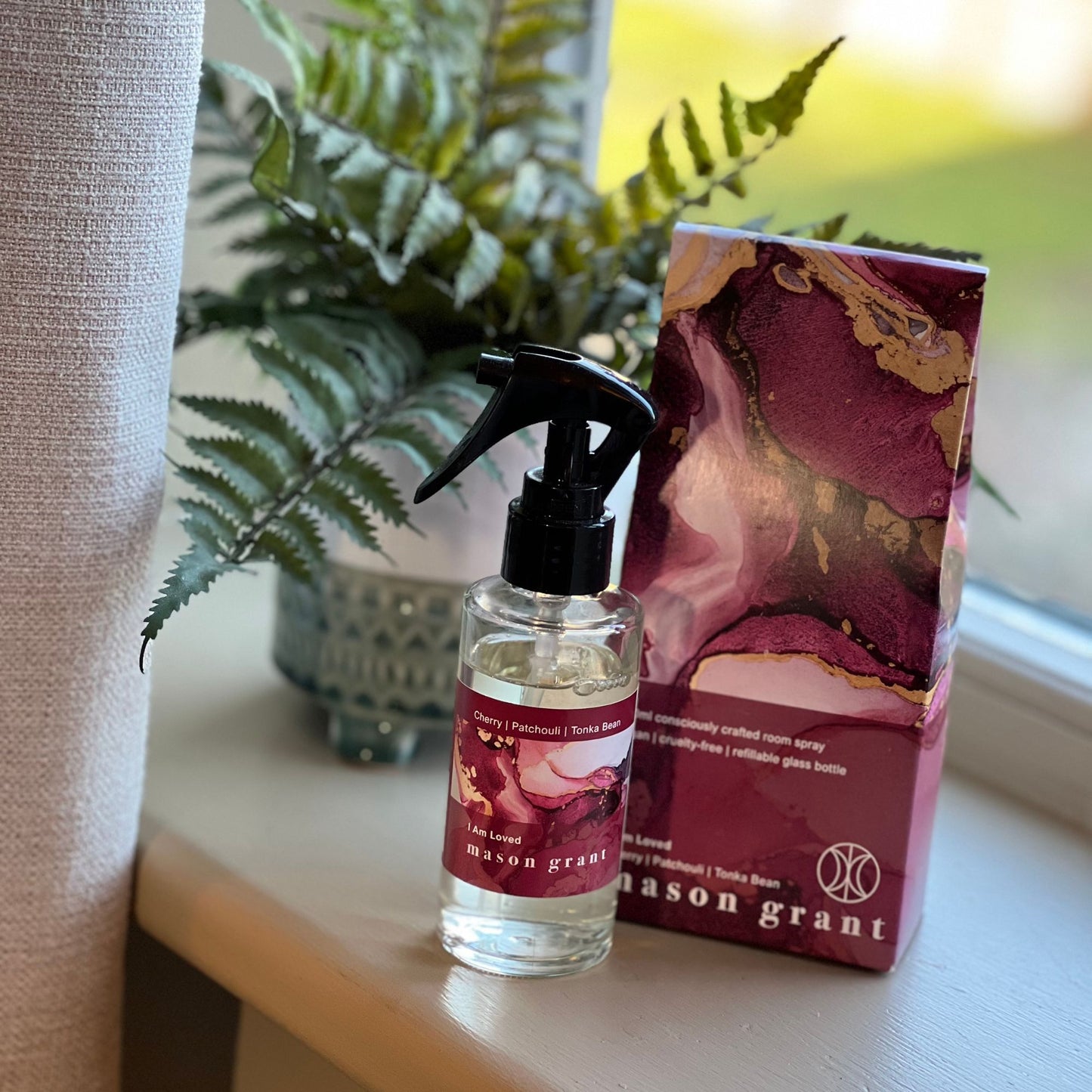 'Mason Grant' Cherry, Patchouli and Tonka Bean Room Spray bottle and box on windowsill with plant