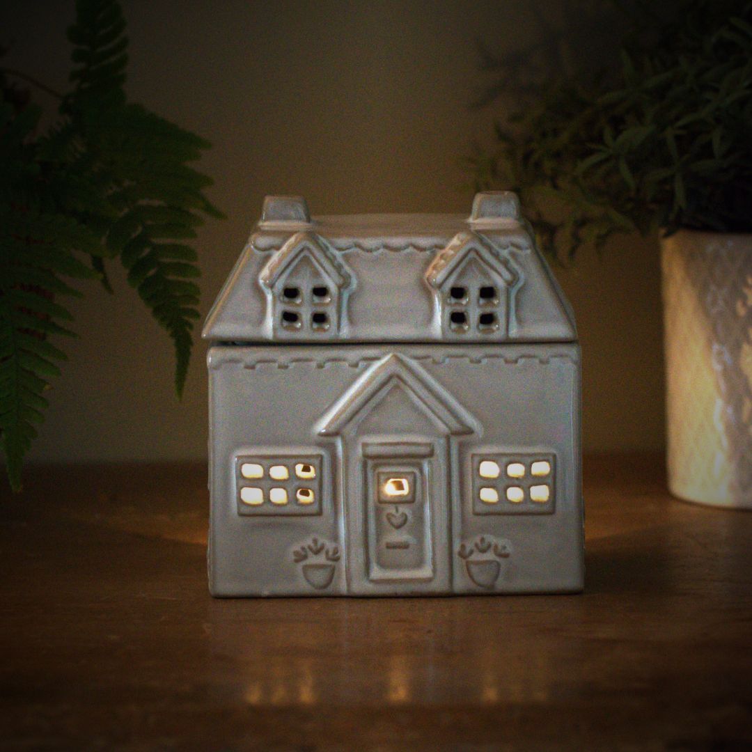 Ceramic house wax burner on wooden table