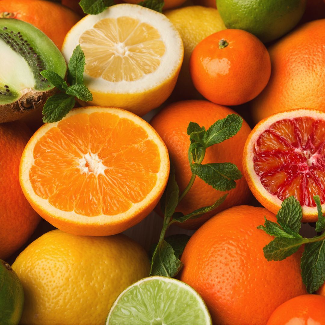 Assorted citrus fruits including oranges, lemons, and limes with mint leaves.