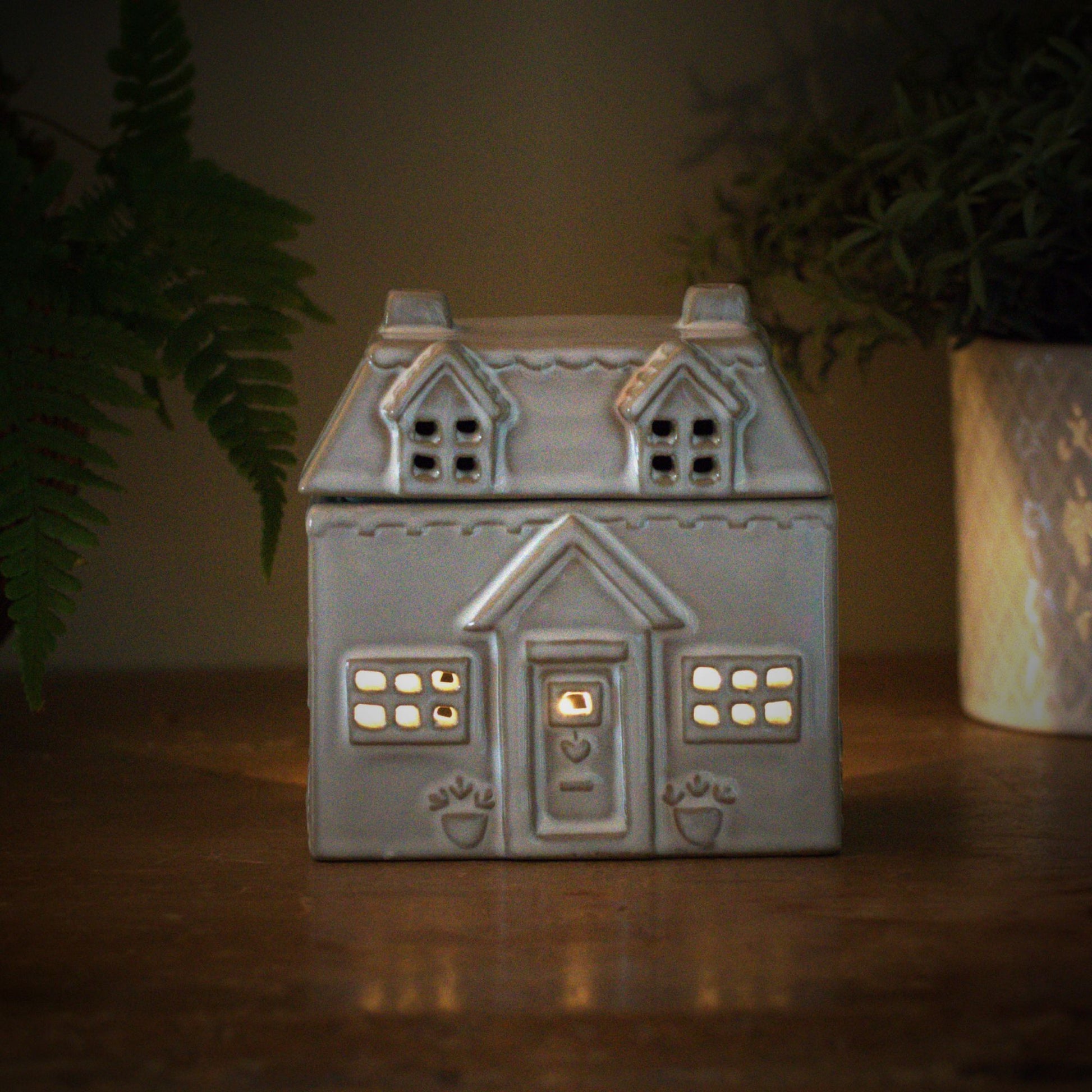 Ceramic house style wax burner with tealight burning inside