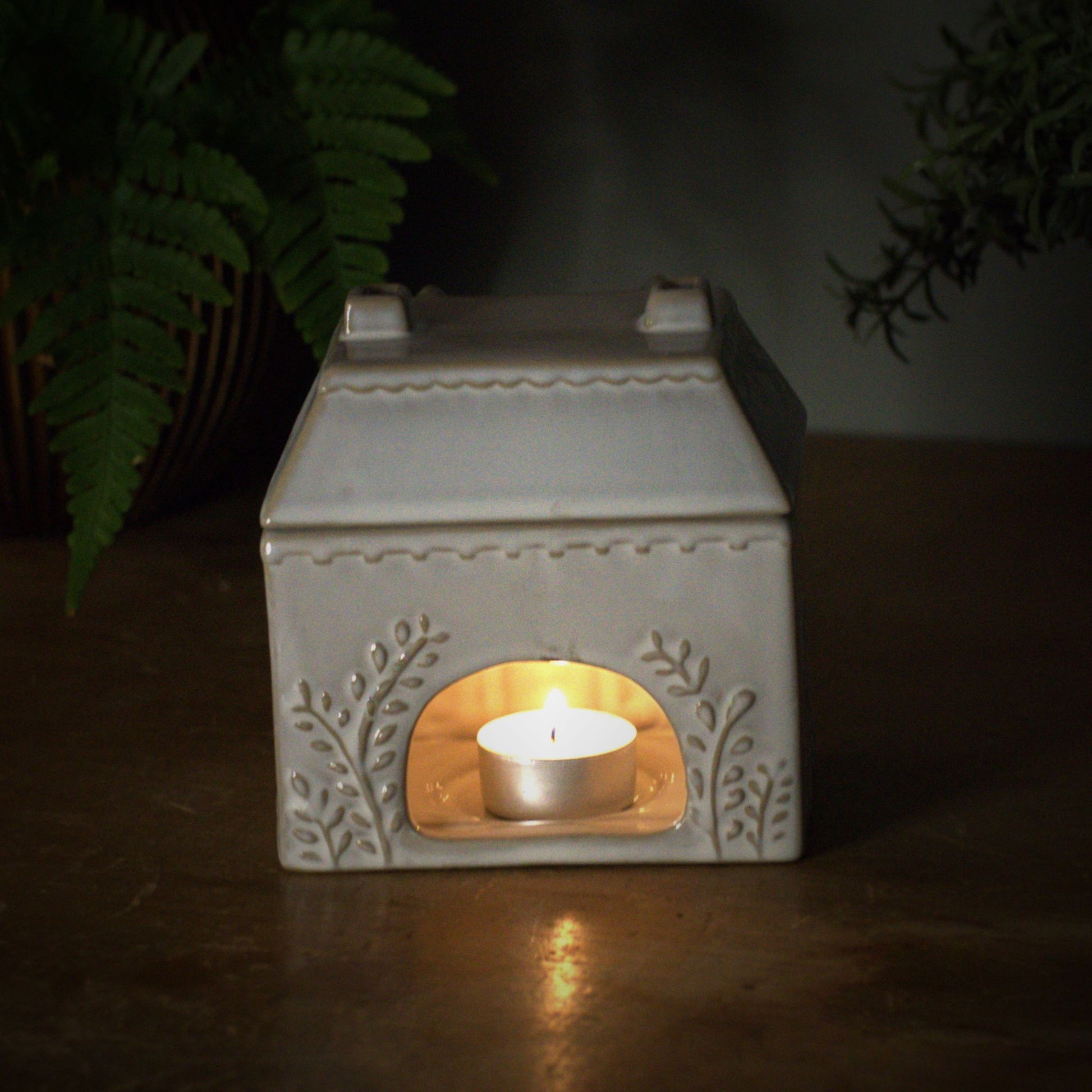 Ceramic house style wax burner with tealight burning inside