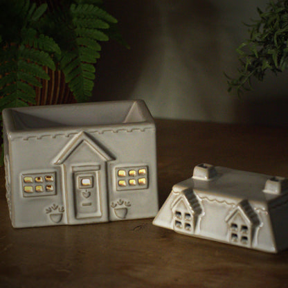 Ceramic house style wax burner with tealight burning inside