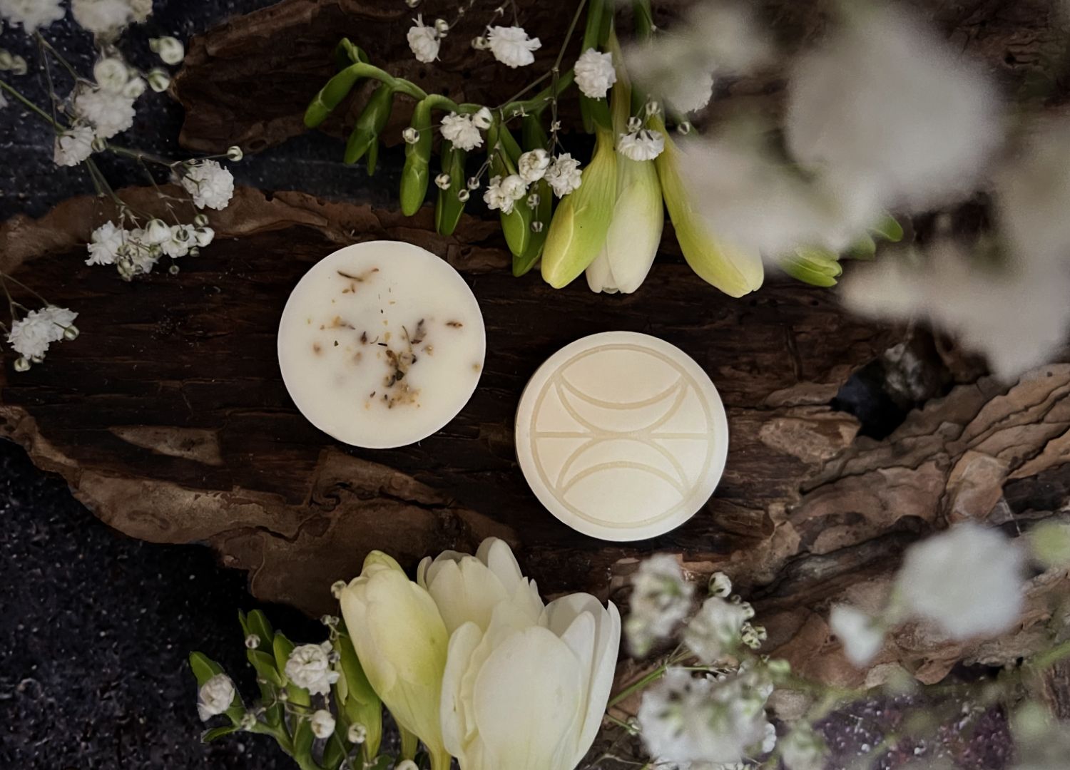 Mason Grant branded soy wax melts on tree bark with green and white flowers