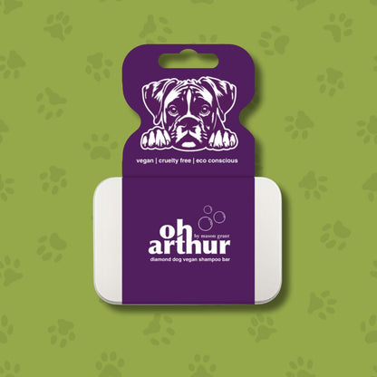 Dog shampoo bar packaging with purple label featuring a dog illustration on a green background with paw prints.