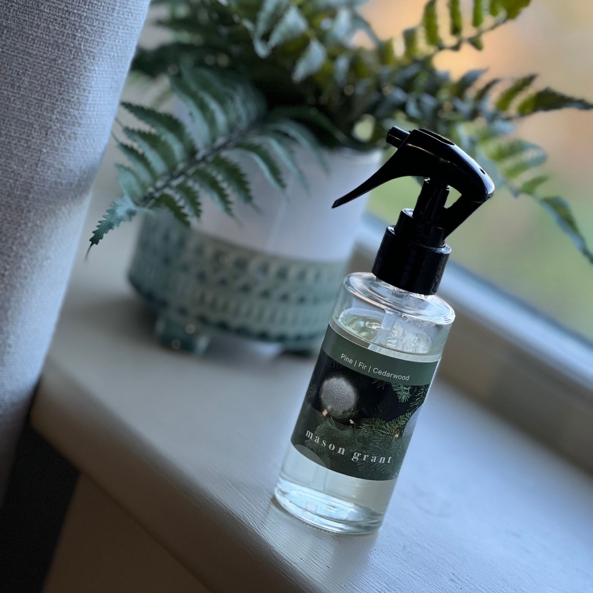 'Mason Grant' Pine, Fir and Cedarwood Room Spray bottle and box on windowsill with plant