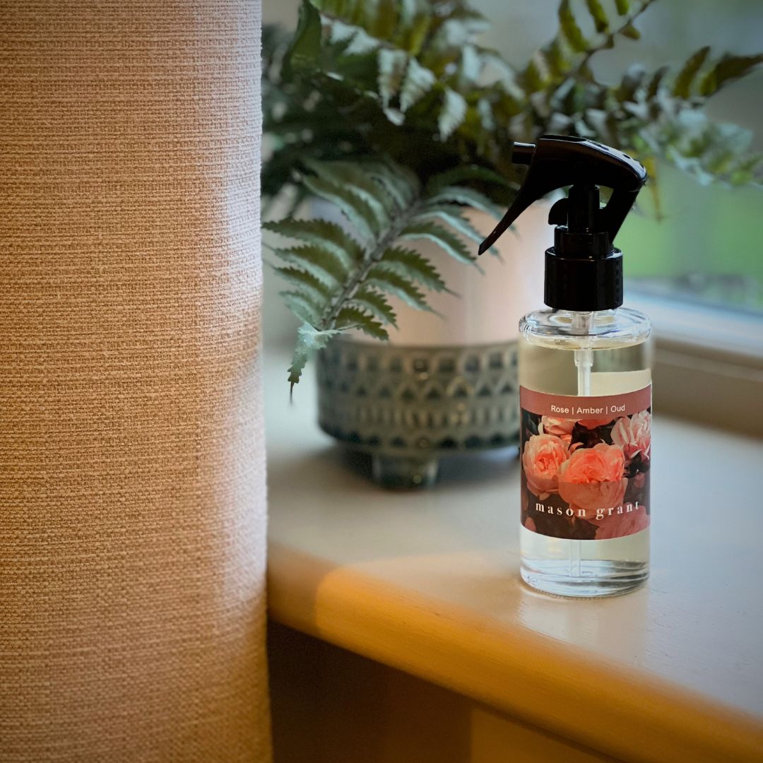 Mason Grant Rose, Amber and Oud Room Spray on windowsill with plant