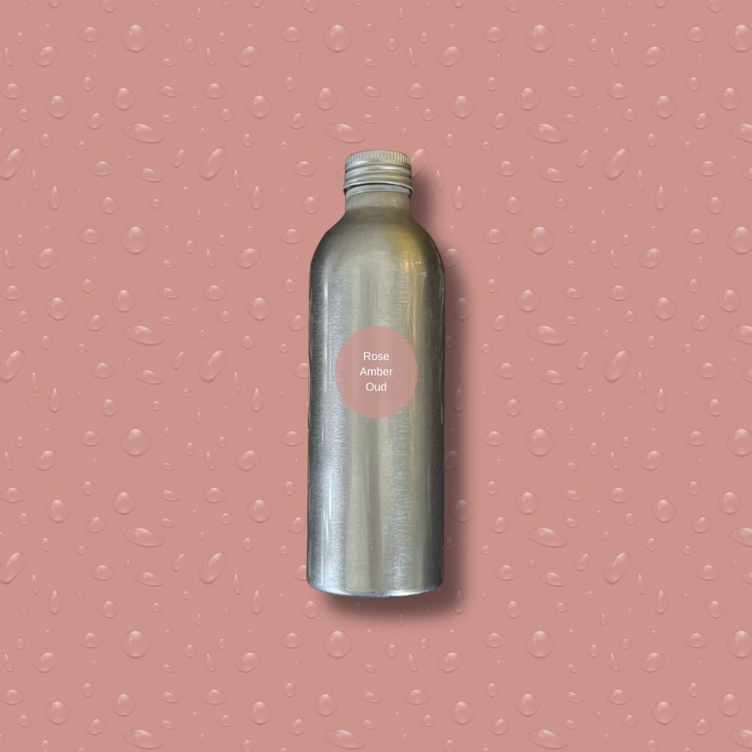 Silver bottle with reeds on a pink textured background